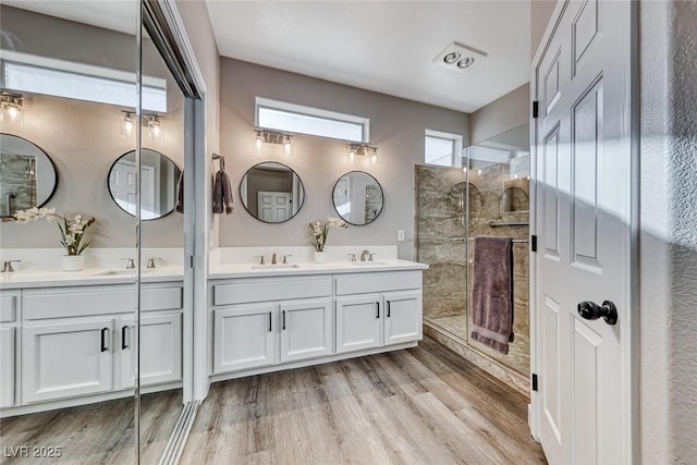 bathroom featuring hardwood / wood-style floors, walk in shower, and vanity