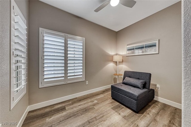 living area featuring hardwood / wood-style flooring and ceiling fan