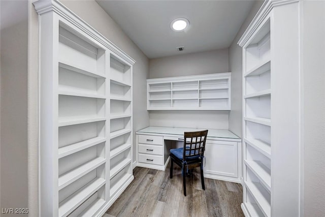 office area with light wood-type flooring and built in desk