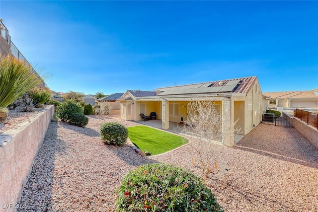 rear view of house featuring a patio and solar panels