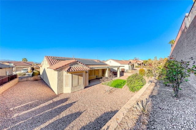 back of property featuring a patio area and solar panels