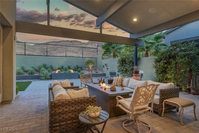 patio terrace at dusk with an outdoor living space with a fire pit