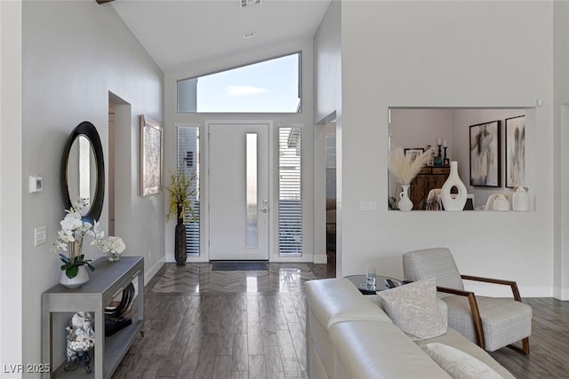 entrance foyer featuring high vaulted ceiling and dark wood-type flooring