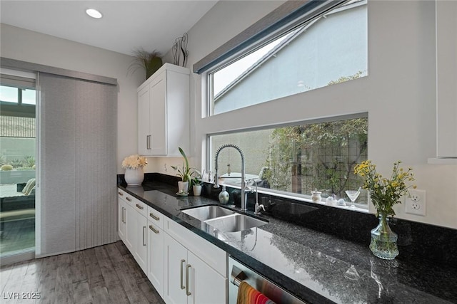 kitchen featuring white cabinets, dishwasher, dark stone counters, sink, and dark hardwood / wood-style floors