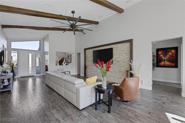 living room with hardwood / wood-style flooring, high vaulted ceiling, ceiling fan, and beam ceiling