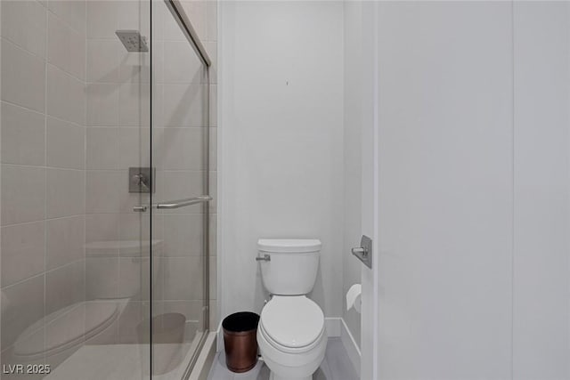 bathroom featuring toilet and a shower with shower door