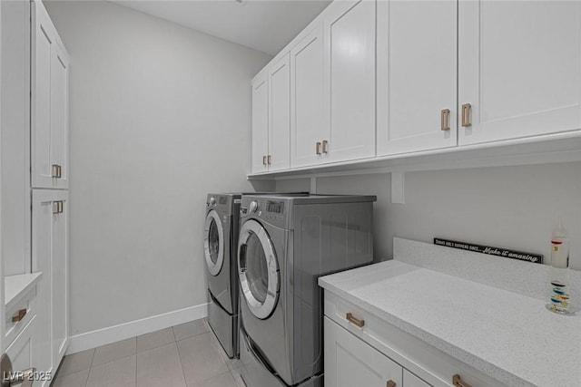 laundry area featuring separate washer and dryer, cabinets, and light tile patterned flooring