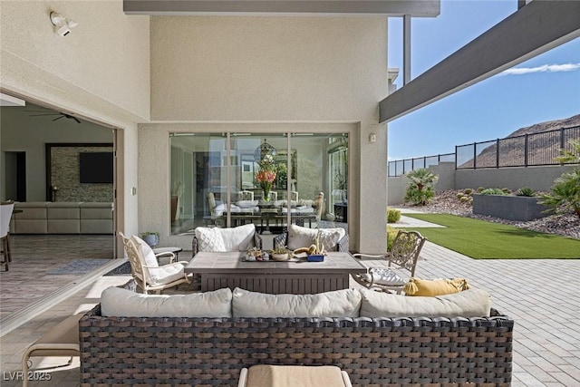 view of patio with an outdoor living space and ceiling fan