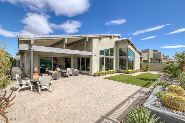 back of property with a patio area, a yard, and an outdoor hangout area