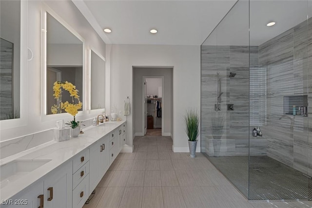 bathroom featuring a shower with door and vanity