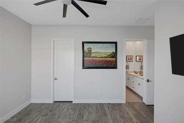 unfurnished room with light wood-type flooring, ceiling fan, and sink