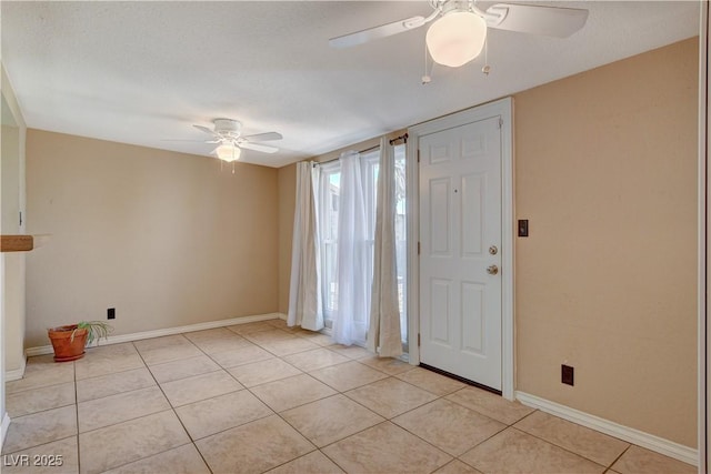 foyer entrance with ceiling fan, a textured ceiling, and light tile patterned floors