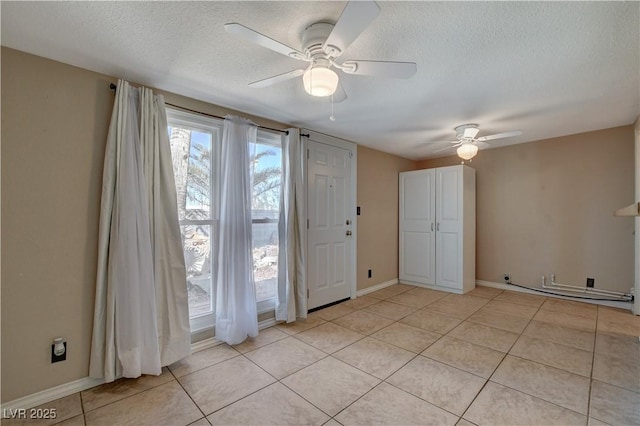 tiled spare room with ceiling fan and a textured ceiling