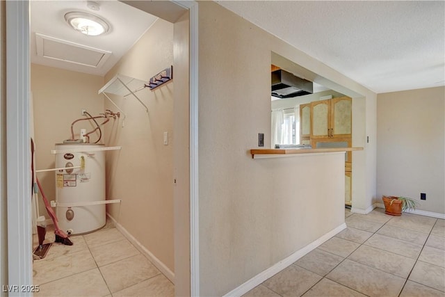 corridor with a textured ceiling, water heater, and light tile patterned floors