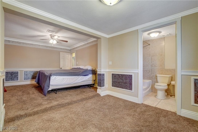 bedroom featuring light carpet, crown molding, and ensuite bath