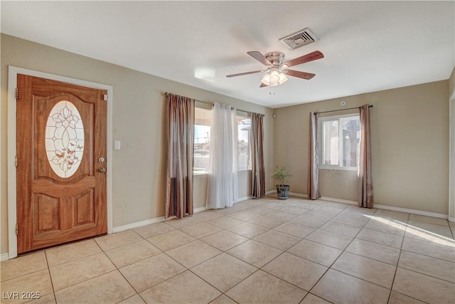 tiled foyer entrance with ceiling fan and plenty of natural light