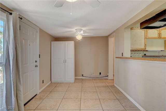 tiled entryway featuring ceiling fan and a textured ceiling