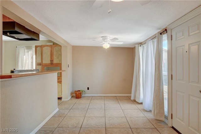 tiled entryway featuring a textured ceiling and ceiling fan