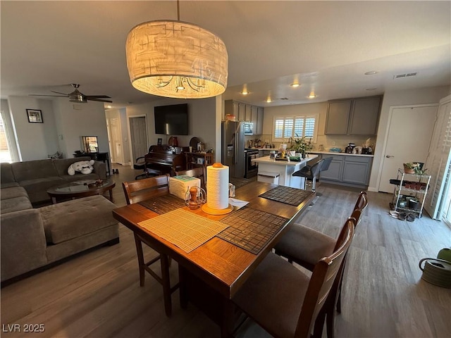 dining room with hardwood / wood-style flooring and ceiling fan