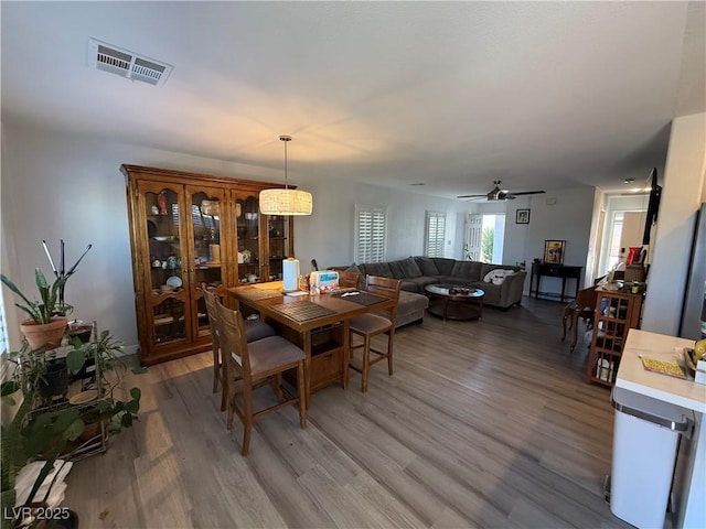 dining space with hardwood / wood-style flooring and ceiling fan