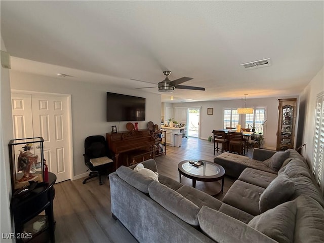 living room featuring ceiling fan and dark hardwood / wood-style flooring