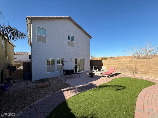 back of house featuring a fire pit and a patio