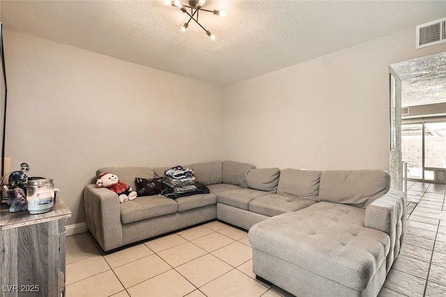 living room featuring a textured ceiling and light tile patterned floors