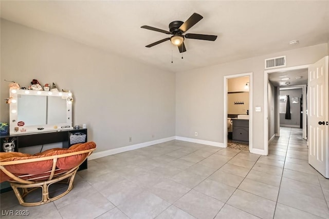 interior space with ceiling fan, light tile patterned floors, and ensuite bath