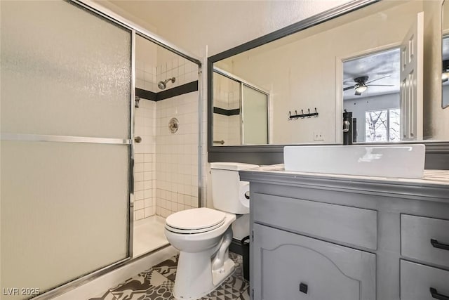 bathroom featuring ceiling fan, an enclosed shower, vanity, and toilet