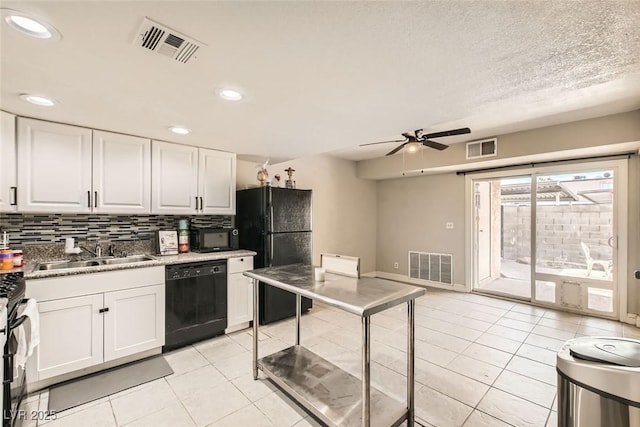 kitchen with sink, white cabinetry, light tile patterned floors, and black appliances