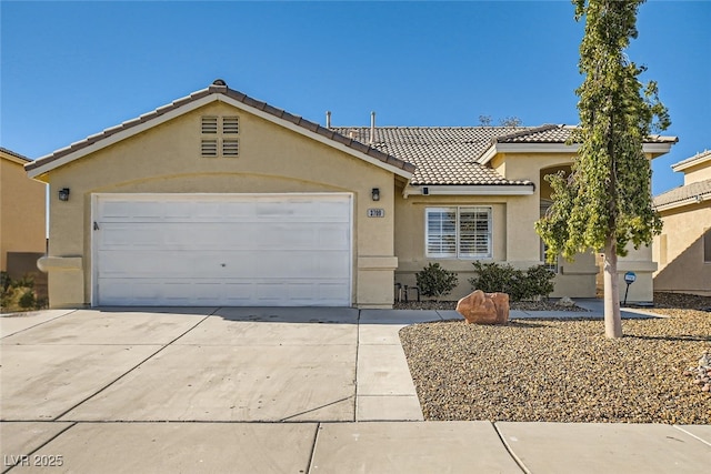view of front facade featuring concrete driveway, a tile roof, an attached garage, and stucco siding