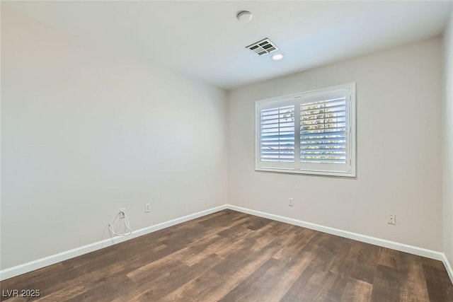 unfurnished room featuring visible vents, baseboards, and dark wood-style flooring