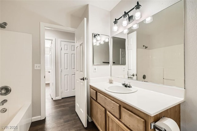 full bathroom with baseboards, vanity,  shower combination, and wood finished floors