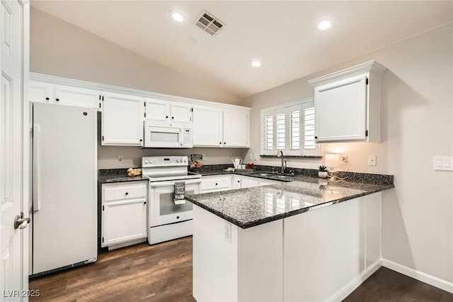 kitchen featuring visible vents, vaulted ceiling, white cabinets, white appliances, and a sink