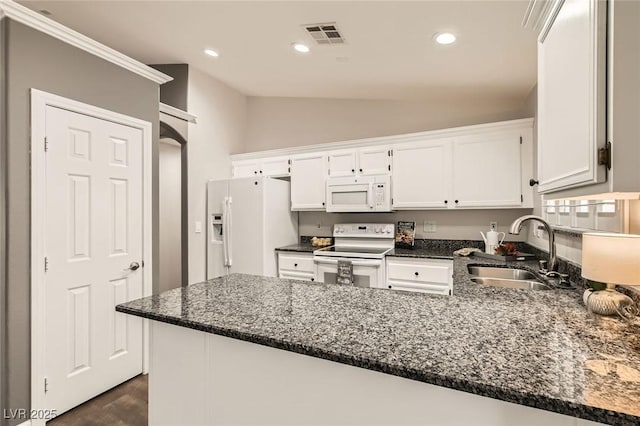 kitchen featuring dark stone counters, a peninsula, white appliances, white cabinetry, and a sink