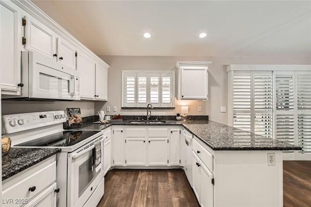 kitchen featuring white appliances, dark wood-style floors, a peninsula, a sink, and white cabinetry