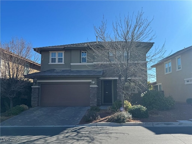 traditional-style home with driveway, stone siding, a garage, and stucco siding