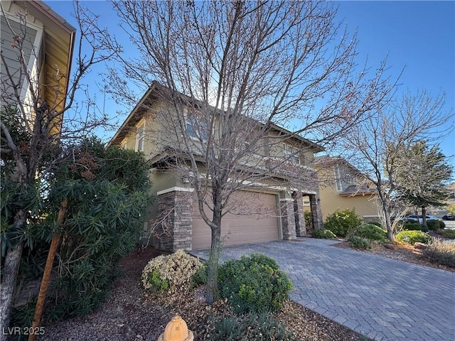 view of front of property featuring a garage, decorative driveway, and stucco siding