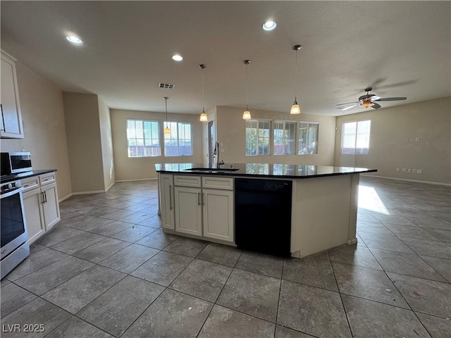 kitchen with white cabinetry, appliances with stainless steel finishes, sink, and an island with sink