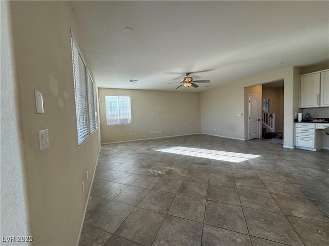 empty room featuring tile patterned floors and ceiling fan