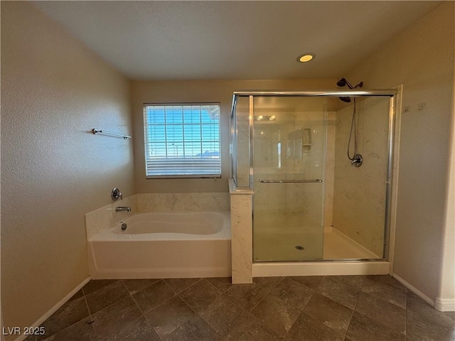 full bathroom with a stall shower, baseboards, and a bath