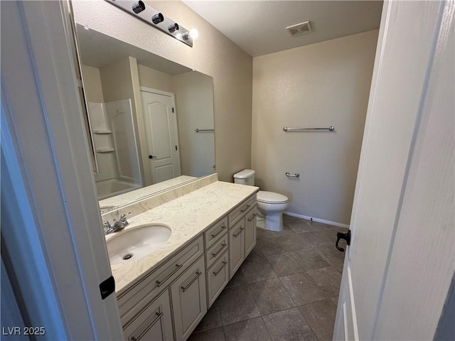 bathroom featuring walk in shower, vanity, toilet, and tile patterned flooring