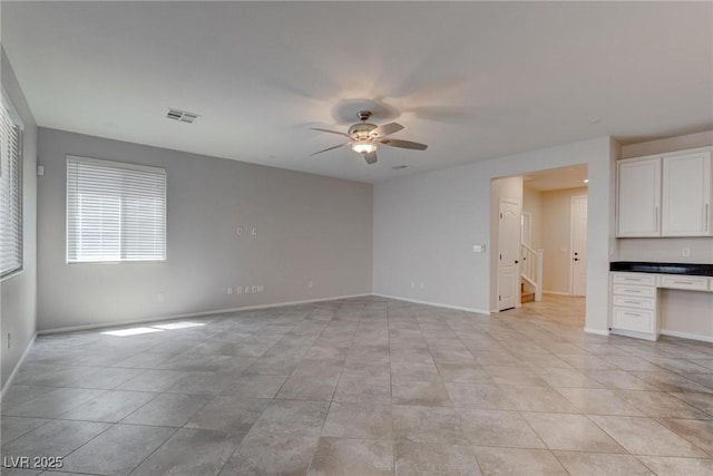 10273 Aragon Crown Rd, Las Vegas, NV 89135 - empty room with ceiling fan, stairs, baseboards, and light tile patterned floors
