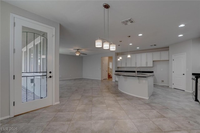 10273 Aragon Crown Rd, Las Vegas, NV 89135 - kitchen featuring dark countertops, open floor plan, a sink, white cabinetry, and baseboards