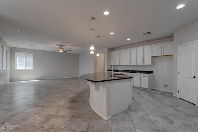 10273 Aragon Crown Rd, Las Vegas, NV 89135 - kitchen featuring a sink, dark countertops, ceiling fan, light tile patterned floors, and white cabinetry