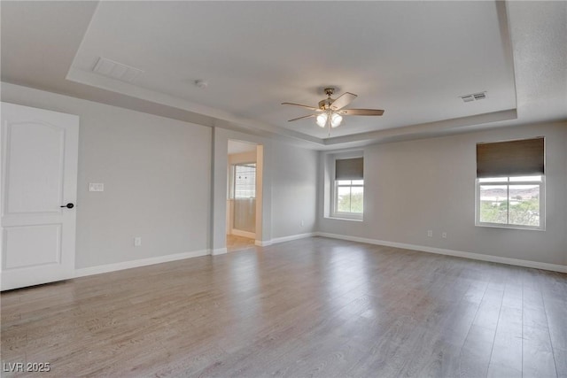 10273 Aragon Crown Rd, Las Vegas, NV 89135 - unfurnished room featuring a tray ceiling, a ceiling fan, wood finished floors, and baseboards