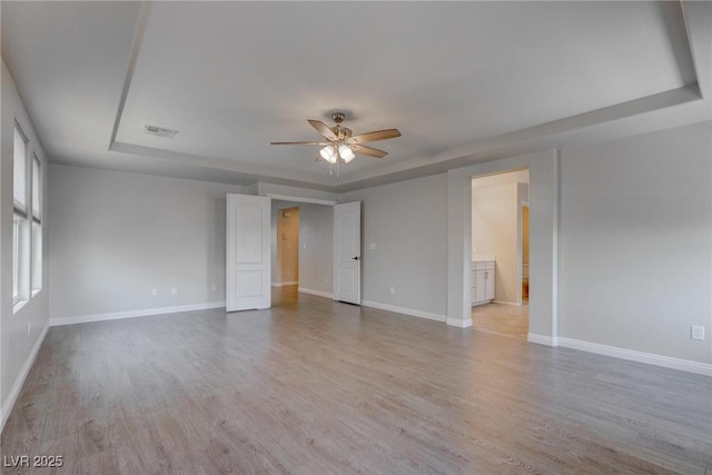 10273 Aragon Crown Rd, Las Vegas, NV 89135 - unfurnished room with a ceiling fan, light wood-style flooring, baseboards, and a raised ceiling