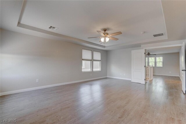10273 Aragon Crown Rd, Las Vegas, NV 89135 - spare room featuring a ceiling fan, a raised ceiling, baseboards, and light wood-style flooring