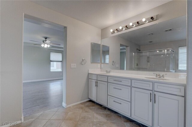 10273 Aragon Crown Rd, Las Vegas, NV 89135 - bathroom featuring a shower stall, baseboards, double vanity, ceiling fan, and tile patterned floors