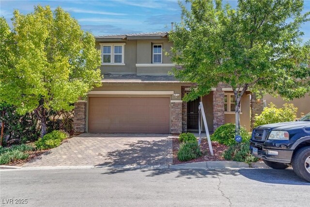 10273 Aragon Crown Rd, Las Vegas, NV 89135 - view of front of home with an attached garage, stucco siding, decorative driveway, and stone siding